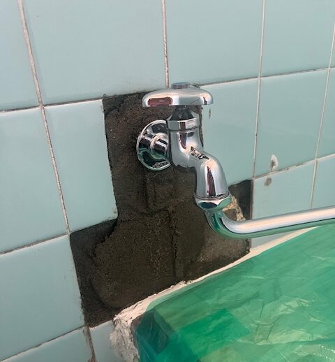 亀裂の入った水道管を新しい配管へ交換している作業スタッフの手元（大阪市東住吉区）